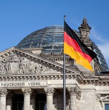 Deutscher Bundestag mit Deutschlandfahne | Bildquelle Fotolia Deutscher Bundestag mit Kuppel davor eine wehende Deutschlandfahne