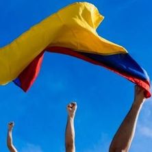 Protest in Kolumbien | Bildquelle: Shutterstock hochgestreckte, zur Faust geballte Hände als Zeichen des Protests, eine mit kolumbianischer Fahne