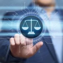 Person im Hintergrund tippt auf einem Bildschirm die Justizwage an