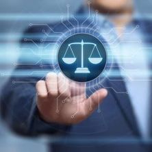 Person im Hintergrund tippt auf einem Bildschirm die Justizwage an