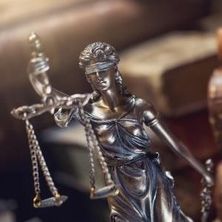 Justitia-Figur vor Büchern