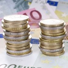 zu Türmen gestapelte Euromünzen, darunter Euroscheine