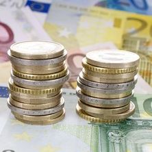 zu Türmen gestapelte Euromünzen, darunter Euroscheine