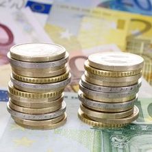 zu Türmen gestapelte Euromünzen, darunter Euroscheine