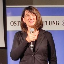 Justiz in Dialog in Rostock - Justizministerin Jacqueline Bernhardt | Quelle: Katrin Klein Justizministerin des Landes Mecklenburg-Vorpommern, Frau Jacqueline Bernhardt, mit Mikrofon in der Hand beim Grußwort der Veranstaltung