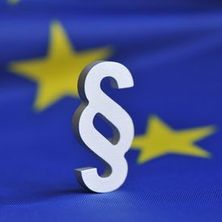 Paragrafenzeichen vor EU-Fahne | Bildquelle Fotolia Paragrafenzeichen vor europäischer Fahne